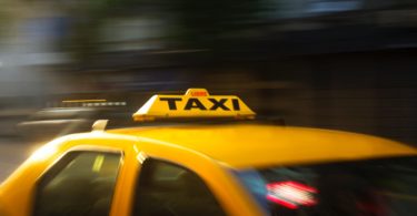 panning photography of yellow taxi