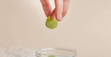 a person holding a green gummy