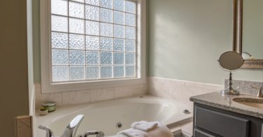 white ceramic bathtub near white ceramic bathtub bathroom