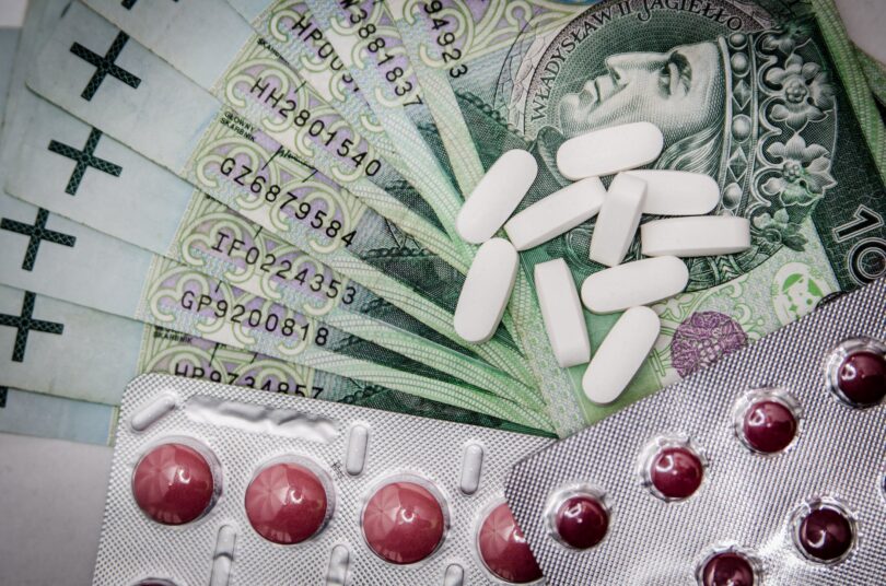 white oval medication pill beside blister pack medical money health