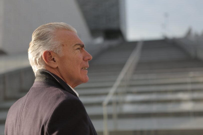 serious elderly gentleman on stone stairs in city