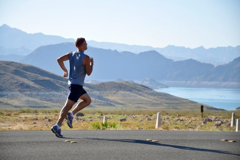 man running on side of road