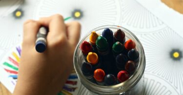 person coloring art with crayons