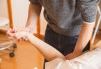 crop chiropractor massaging hand of patient
