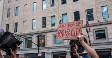 protester holding a sign on police brutality