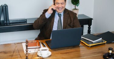 happy asian lawyer talking on smartphone in law office