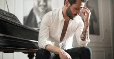 dramatic tattooed male sitting at piano