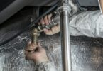 plumber installs pipe fittings