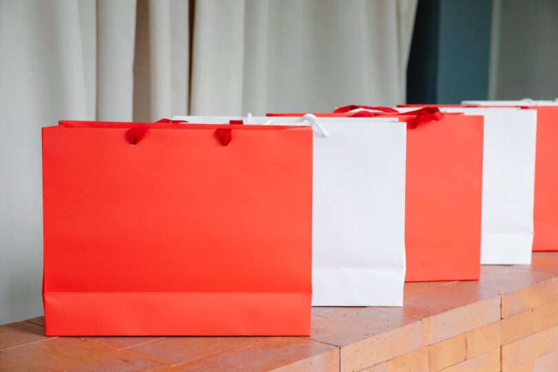 similar white and red shopping bags on brick counter