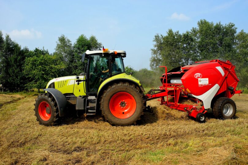 red yellow and white tractor on grass field during daytime