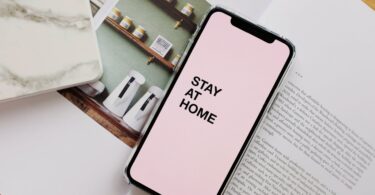 smartphone screen with stay at home inscription during coronavirus pandemic